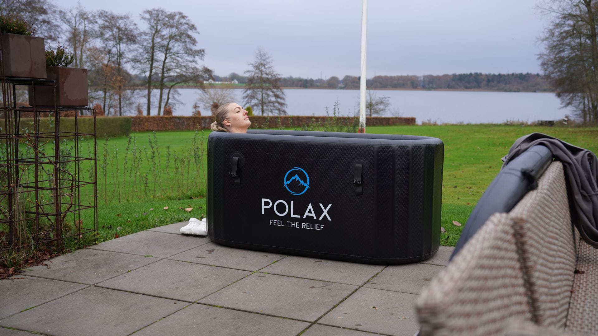 Kvinna njuter av fördelarna med Polax isbad Pro modell i trädgården hemma.